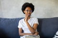 African American girl writes in a notebook in a cozy room