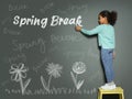 African American girl writing phrase Spring Break with chalk on grey wall. School holiday Royalty Free Stock Photo