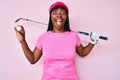 African american golfer woman with braids holding golf ball celebrating crazy and amazed for success with open eyes screaming Royalty Free Stock Photo