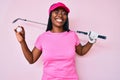 African american golfer woman with braids holding golf ball winking looking at the camera with sexy expression, cheerful and happy Royalty Free Stock Photo
