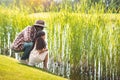 african american granddaughter and her grandfather sitting near lake