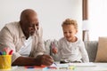 African American Grandfather And Little Grandchild Drawing At Home Royalty Free Stock Photo