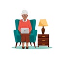 African american Grandma sits in a chair with a laptop Royalty Free Stock Photo