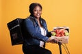 African american grocery deliverywoman riding bike while delivering box full with healthy vegetables to client Royalty Free Stock Photo