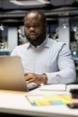 African american guy answering emails and documenting data from online insights Royalty Free Stock Photo