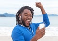 African american guy with dreadlocks listening to music at beach Royalty Free Stock Photo