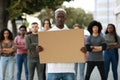 African american guy with empty placard leading group of protestors