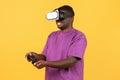 African american guy experiencing virtual reality wearing VR headset, studio Royalty Free Stock Photo