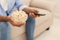 Man holding tv remote controller and popcorn in hands Royalty Free Stock Photo