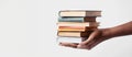 African American hand holding stack of hardcover books. Collection of old books in black female hand. White background Royalty Free Stock Photo