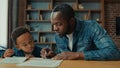 African American happy family little boy child schoolboy with father writing homework. Dad help son with lesson class Royalty Free Stock Photo