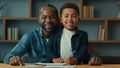 African American happy family portrait smiling at camera little boy child schoolboy with father at table help with Royalty Free Stock Photo