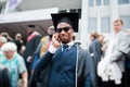 African american happy man at graduation. Graduated student speaking phone at crowd of people Royalty Free Stock Photo