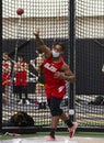 African American high school boy throwing the shot put indoors