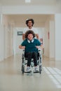 African-American hospital technician compassionately navigating the hospital hallways, pushing his wheelchair-bound