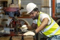 African American industrial worker is using hydraulic power press machine to make metal and steel part while working inside the Royalty Free Stock Photo