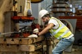 African American industrial worker is using hydraulic power press machine to make metal and steel part while working inside the Royalty Free Stock Photo