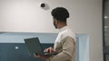 African american installer sets up security camera in office