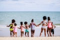 African American, Kids group in swimwear enjoying running to play the waves on beach. Ethnically diverse concept. Having fun after