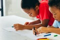 African American kids learning how to draw with crayon on table