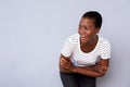 African american lady laughing with arms crossed and looking away against gray background