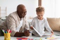 African American Little Boy Showing Drawings To Grandpa At Home Royalty Free Stock Photo