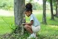 African American little girl using magnifying glass to explore and look bugs on the tree between learning beyond the classroom.
