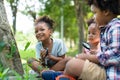 African American little girls with friends exploring and looking bugs on the tree with the magnifying glass between learning Royalty Free Stock Photo