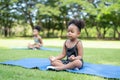 African American little girls sitting with their eyes closed on roll mat practicing meditate yoga in the park. Kids afro girls Royalty Free Stock Photo