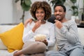 African american lovers watching movie, eating popcorn, home interior Royalty Free Stock Photo