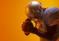 African american male american football player holding ball with neon orange lighting