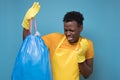 African american male in apron and gloves holding a stinky garbage bag