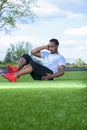 African American male athlete is doing sit up exercises on a green grass Royalty Free Stock Photo