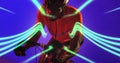 African american male athlete wearing helmet riding bike by illuminated lines on blue background