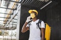 African American male courier food delivery in face mask with yellow thermal backpack