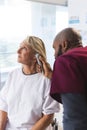 African american male doctor examining senior female caucasian patient using otoscopy Royalty Free Stock Photo