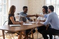 African american male employee shaking hands with teammate at office.