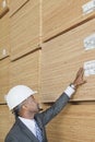 African American male engineer inspecting wooden planks Royalty Free Stock Photo