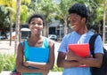 African american male and female student walking on campus Royalty Free Stock Photo