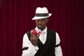 African American male gambler in retro suit holding over size dice