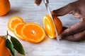 African American Male Hand slicing oranges on white marble tray. Healthy Citrus Fruit