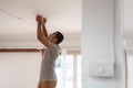 African American Man changing light bulb during COVID-19 quarantine at home Royalty Free Stock Photo