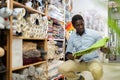 African American male shopper choosing rug at store Royalty Free Stock Photo