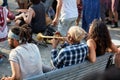 African American male sitting on a bench and blowing trumpet at Tam Tams festival in Mount Royal Park