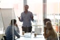 Black male coach make whiteboard presentation for employees Royalty Free Stock Photo