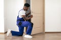 African American Male Worker Installing New Door In Apartment Indoor Royalty Free Stock Photo