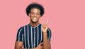 African american man with afro hair wearing casual clothes with a big smile on face, pointing with hand and finger to the side