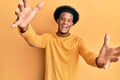 African american man with afro hair wearing casual clothes looking at the camera smiling with open arms for hug Royalty Free Stock Photo