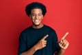 African american man with afro hair wearing casual clothes smiling and looking at the camera pointing with two hands and fingers Royalty Free Stock Photo