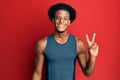 African american man with afro hair wearing sportswear smiling with happy face winking at the camera doing victory sign Royalty Free Stock Photo